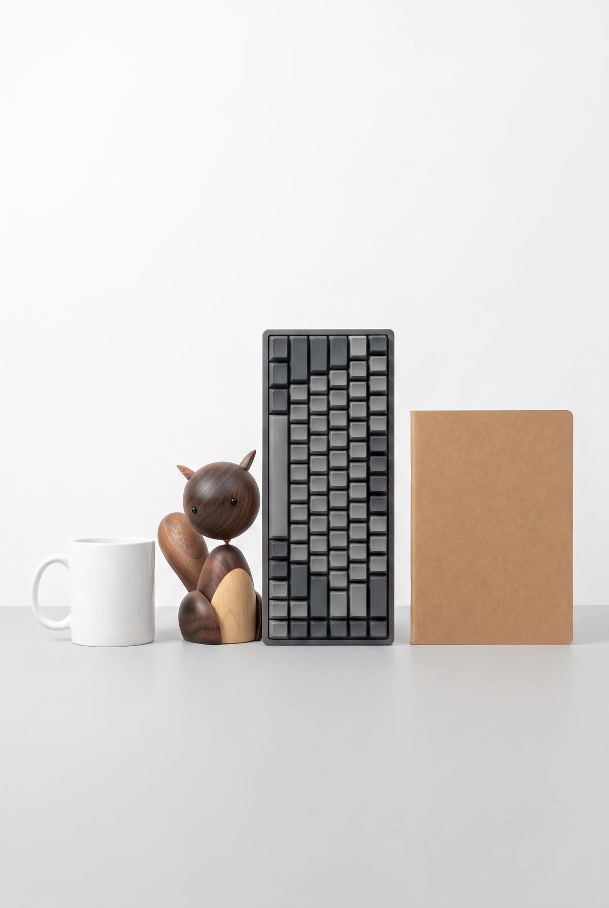 11 cm Nordic black walnut squirrel sculpture beside a mug, keyboard, and notebook for scale.