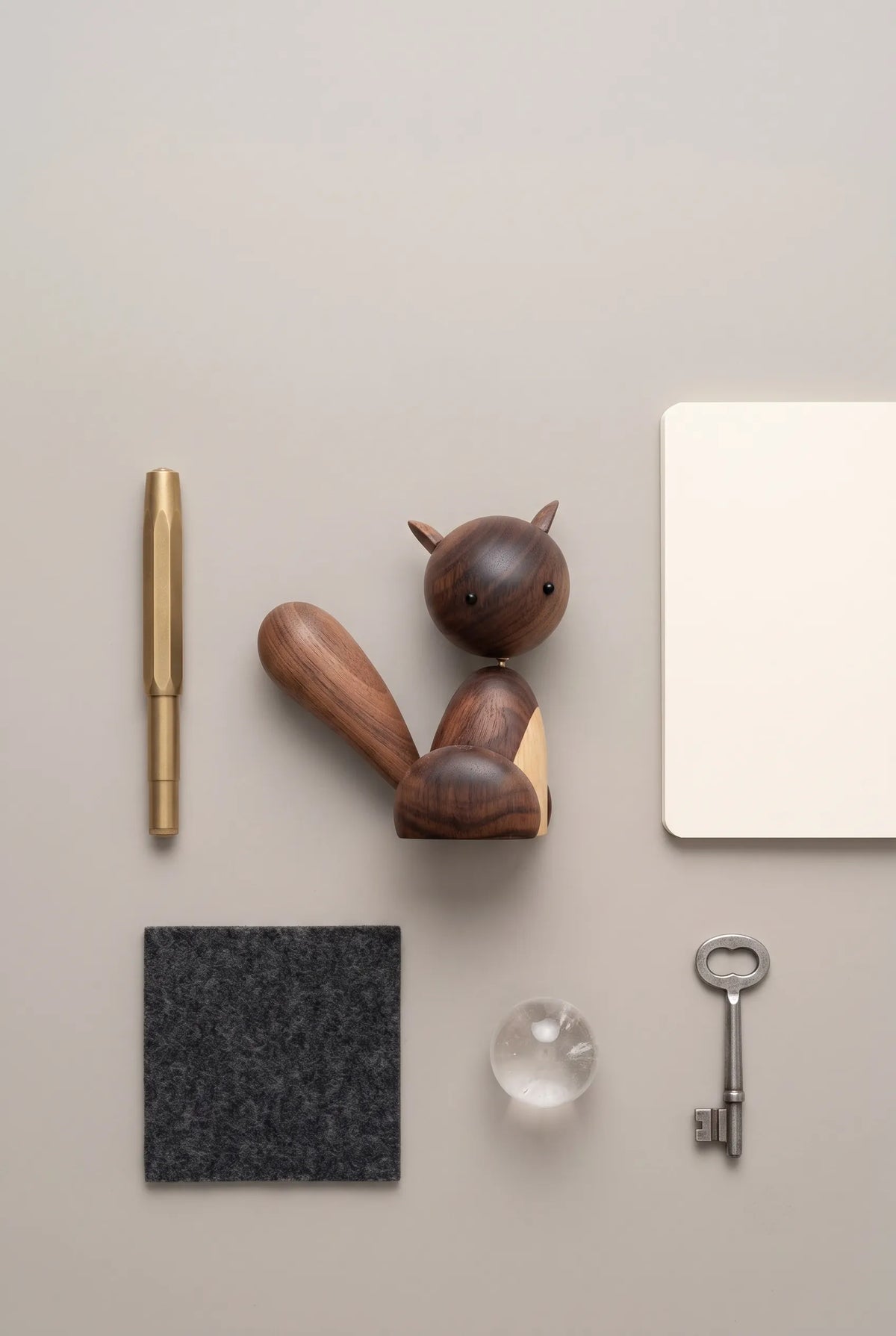 Top-down view of the complete Nordic black walnut squirrel sculpture arranged with simple desk essentials.