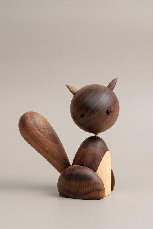 Nordic black walnut squirrel sculpture with a rounded body and swept tail on a greige background.