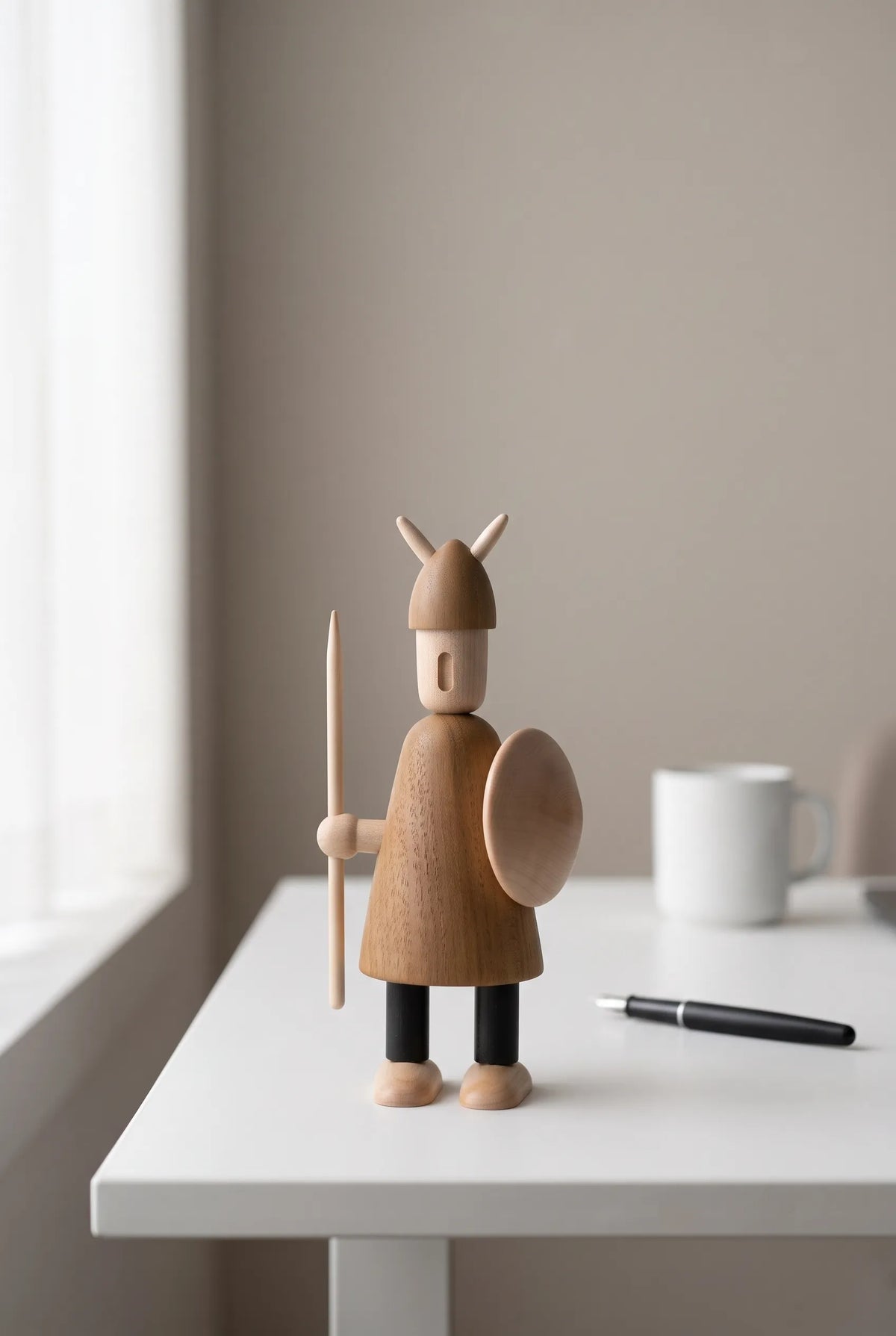 Nordic Mythos Viking Wood Sculpture crafted from Solid Teak and Natural Maple Wood with light-absorbing matte wood grain finish, positioned in a minimalist workspace with muted environmental tones.
