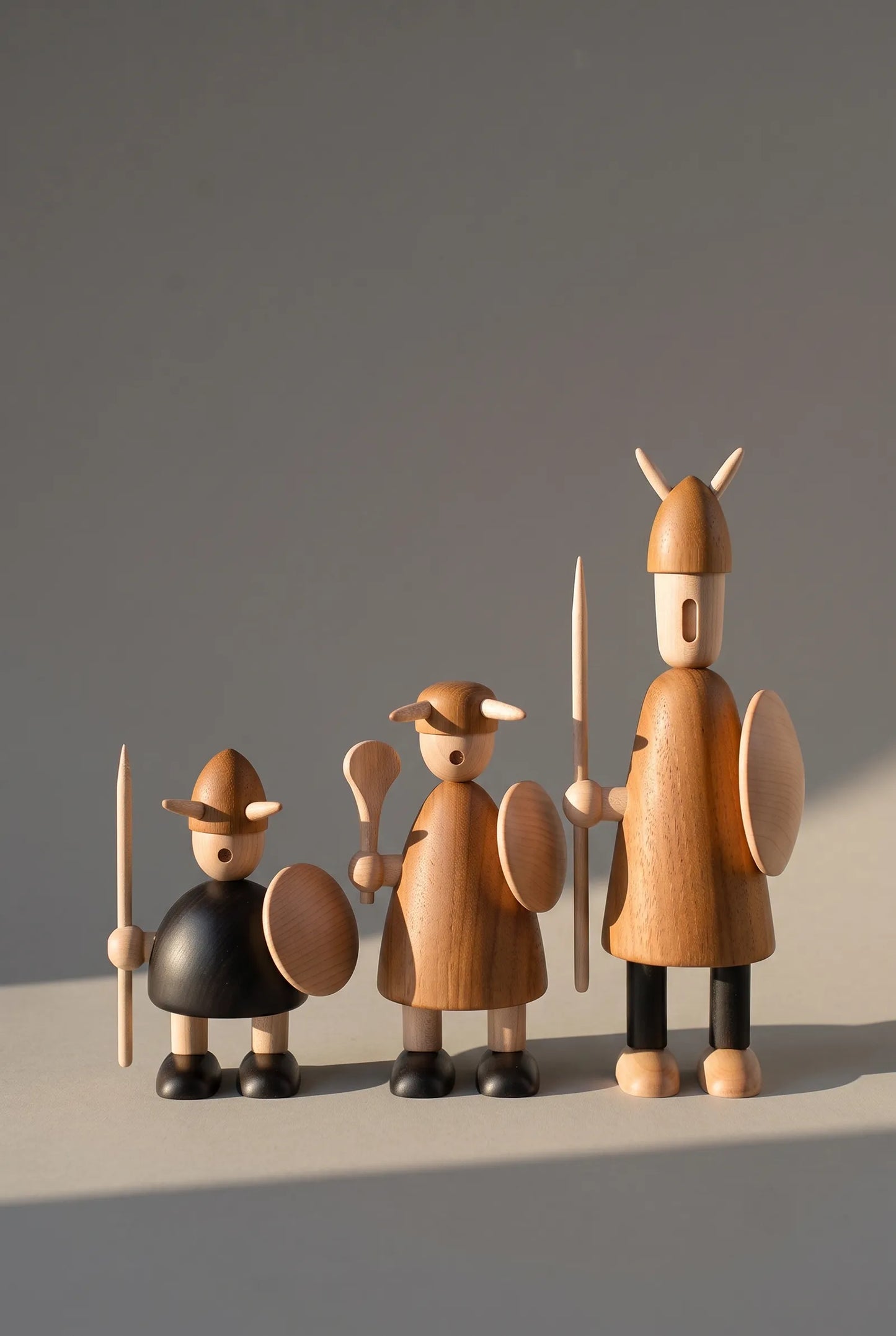 Nordic Mythos Viking Wood Sculptures crafted from Solid Teak and Natural Maple, showing authentic material saturation under 45-degree lateral golden hour illumination.