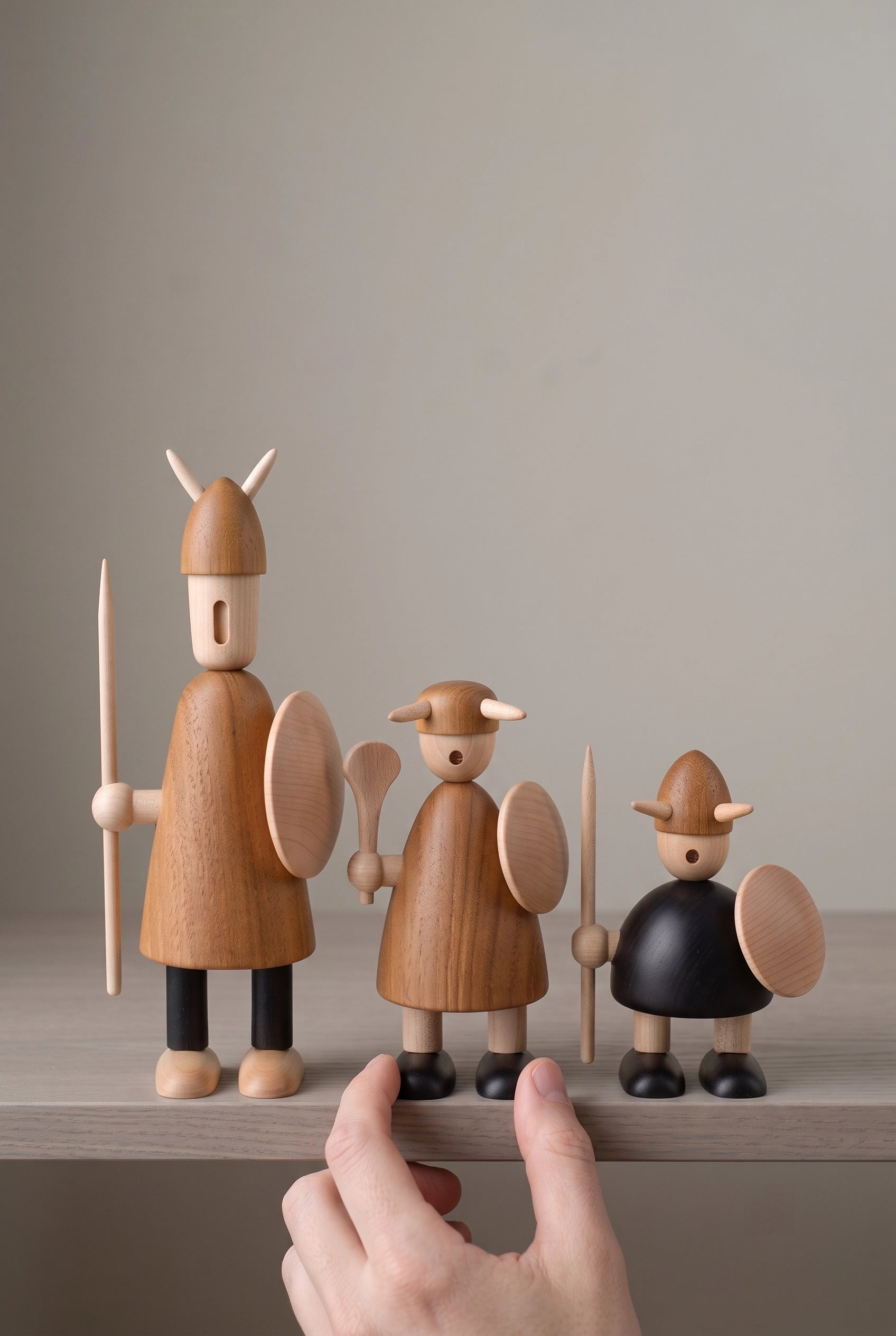 Nordic Mythos Viking Wood Sculptures crafted from Solid Teak and Natural Maple with Glare-free matte natural oil finish, touched gently by a relaxed hand at the lower frame edge.
